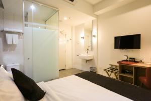 吉隆坡J大道酒店 - 中央市场的一间卧室配有一张床,浴室设有水槽