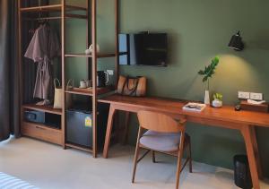 奥南海滩Mini House Aonang Hotel SHA Plus的客房设有一张桌子、一把椅子和一台电视