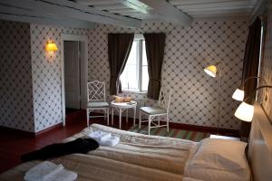 SvartåMustion Linna / Svartå Manor的卧室配有1张床、1张桌子和1把椅子
