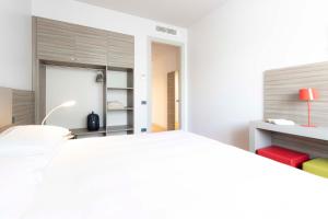 San Quirino普莉姆拉酒店的白色卧室配有白色的床和衣柜