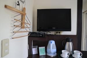 达沃市多米西里奥洛伦佐酒店的客厅配有电视和带杯子的桌子