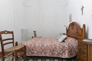 GiuggianelloLa Torre Antica Dimora的一间卧室配有一张床、一把椅子和一个梳妆台