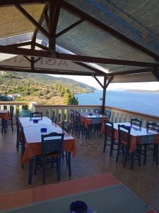 KalamakiaAgnanti Hotel的一间带桌椅并享有水景的餐厅