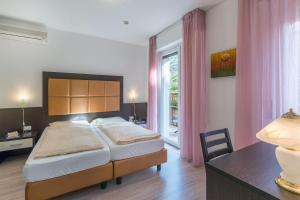 马尔切西内卡门维拉酒店的一间卧室配有一张床、一张书桌和一个窗户。