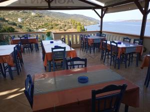KalamakiaAgnanti Hotel的一间带桌椅的海景餐厅