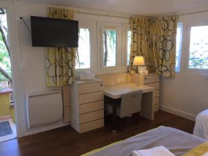 滨海萨纳里夫瑞古莱特农舍旅馆的一间卧室配有书桌、一张床和电视。