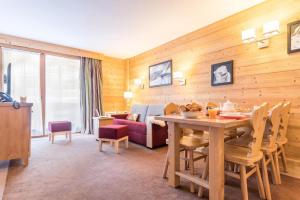 谷雪维尔Résidence Les Chalets du Forum - Courchevel 1850的客厅配有桌子和沙发