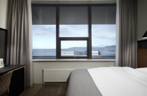 雷克雅未克卡宾酒店的一间卧室设有一张床和一个大窗户