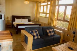 金贾Nile Front Cottages的客厅配有沙发和1张床