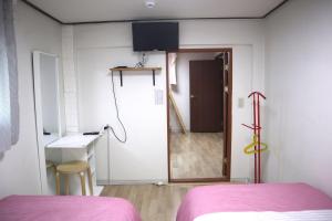 首尔郑家旅馆的一间设有床铺的客房,门通往走廊