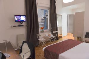 卢森堡富豪齐客栈公寓酒店的酒店客房设有床、桌子和电视。