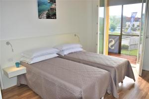 卡梅拉诺ASPIO RESIDENCE的一间卧室设有一张大床和一个大窗户
