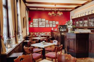 奥斯纳布吕克克鲁特酒店的餐厅拥有红色的墙壁和桌椅