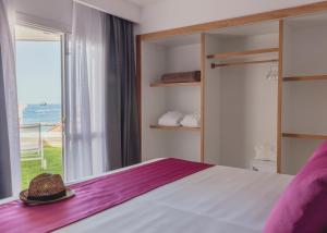 阿德耶火烈鸟海滩伴侣公寓的一间卧室设有一张床和一个大窗户