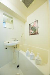 京都Cozyhouse 310 free wifi a rented electric bicycle的白色的浴室设有水槽和浴缸。