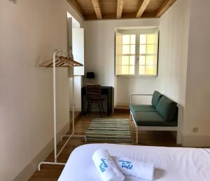 科英布拉Change The World Hostels - Coimbra - Almedina的卧室配有床、椅子和窗户。