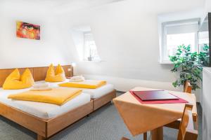 古梅尔斯巴赫Brauhaus Gummersbach GmbH的配有两张带黄色枕头的床铺