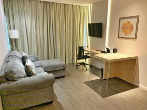 亚松森Holiday Inn Express Asuncion Aviadores , an IHG Hotel的一间客厅,客厅配有沙发和一张书桌,位于酒店的房间