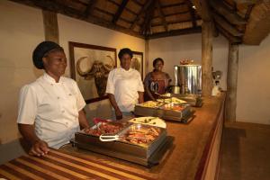 SihangwaneTembe Elephant Park Lodge的三名厨师站在自助餐前