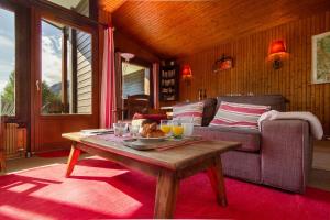 夏蒙尼-勃朗峰Chalet Dava La Via ski in - ski out - Happy Rentals的客厅配有沙发和桌子
