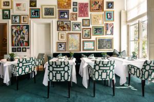 布鲁日范克莱夫酒店的一间设有两张桌子和一幅画墙的用餐室