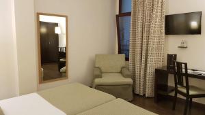 毕尔巴鄂康德杜克毕尔巴鄂酒店的一间卧室配有一张床、一把椅子和一张书桌