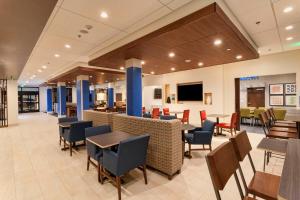 道奇城Holiday Inn Express & Suites - Dodge City, an IHG Hotel的医院里带桌椅的用餐区