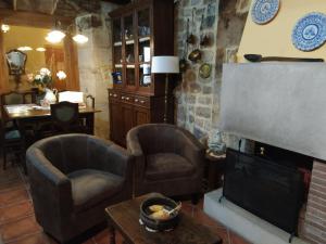 阿里纳斯·德·卡伯瑞勒斯Apartahotel Montecaoru的客厅配有两把椅子和壁炉