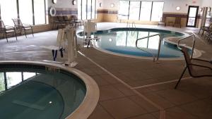 剑桥剑桥智选假日套房酒店的一座游泳池,四周摆放着椅子