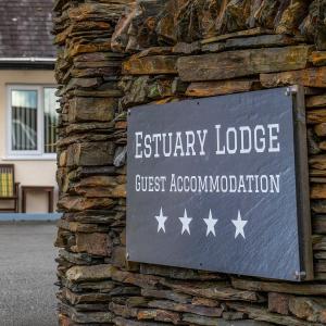 塔桑墨Estuary Lodge Motel B&B的石头建筑的一侧的标志