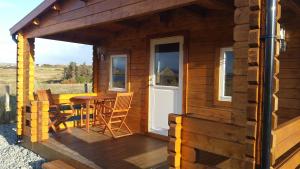 邓韦根Harlosh Log Cabins的小木屋 - 带桌椅的甲板