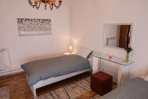 贾科沃Apartman Kaya的一间卧室配有一张床、一张桌子和一面镜子