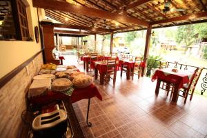 瓜皮米林POUSADA DAS ORQUIDEAS20的餐厅设有桌椅和红色的桌椅
