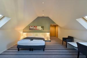 菲茨瑙Hotel Vitznauerhof - Lifestyle Hideaway at Lake Lucerne的阁楼卧室配有床
