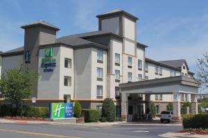 康科德Holiday Inn Express & Suites Charlotte-Concord-I-85, an IHG Hotel的前面有标志的酒店大楼