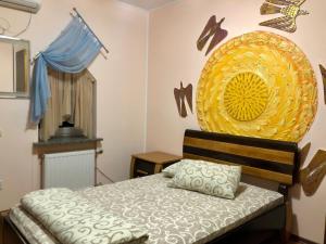 哈尔科夫Arcadia的卧室配有一张床,墙上有一个大黄盘