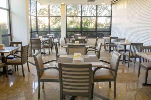 圣贝尔纳多-杜坎普Aparthotel Twin Towers的餐厅设有桌椅和窗户。