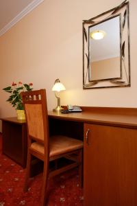 莫德拉Hotel Majolika的客房设有带椅子和镜子的书桌