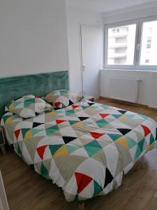 滨海布洛涅T3 Nausicaa Parking gratuit的一间卧室配有一张大床和五颜六色的被子