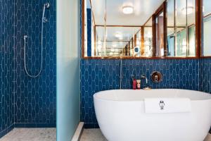 迈阿密Mr. C Miami - Coconut Grove的浴室设有白色浴缸和蓝色瓷砖