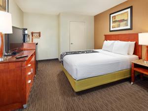 圣地亚哥Mission View Inn & Suites San Diego Sea World - Zoo的配有一张床和一台平面电视的酒店客房