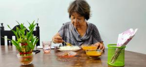 钦奈Hostel Gandhi的坐在餐桌上吃食物的女人