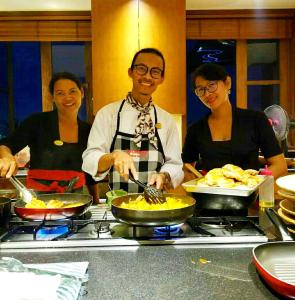 金巴兰巴厘岛金巴兰长屋旅馆的三人在厨房准备食物