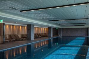 江陵市拓扑斯10号酒店的一座带椅子和天花板的酒店游泳池