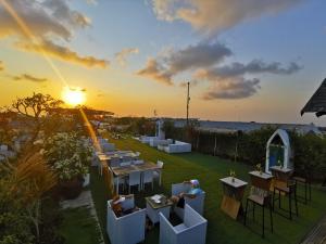 勒吉安阿克玛尼勒吉安酒店的花园的日落美景,配有桌椅
