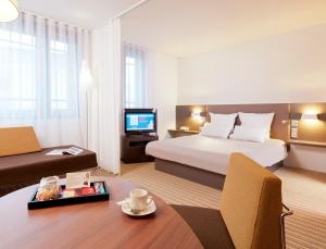 巴黎巴黎蒙特勒伊文森斯诺富特套房酒店的一间酒店客房,配有一张床和一台电视