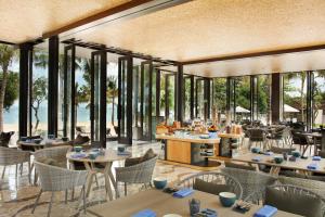 库塔巴厘岛安瓦雅海滩度假酒店的餐厅的 ⁇ 染,配有桌椅