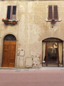 圣吉米纳诺安娜尼多二号招待所的一座带两扇门的建筑,一扇鲜花盛开的窗户