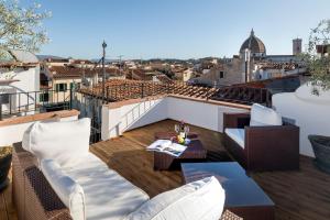 佛罗伦萨Residenza Conte di Cavour & Rooftop的阳台配有白色家具,享有城市美景。