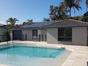 彩虹海滩Coora 13的一座带太阳能电池板的房屋前的游泳池